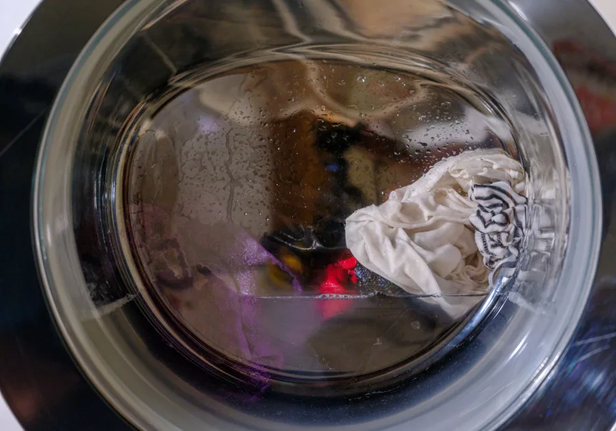 Laundry tumbling inside the drum of a front load washing machine